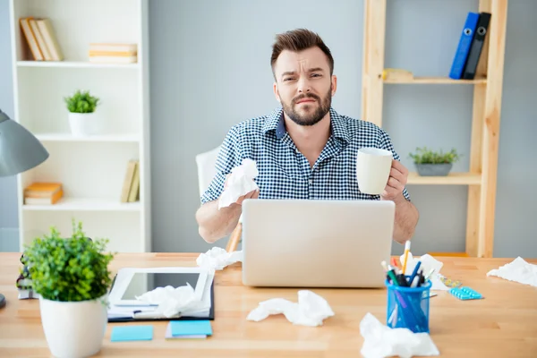 Hombre de negocios enfermo con agarre sentado en la oficina y sosteniendo una taza — Foto de Stock