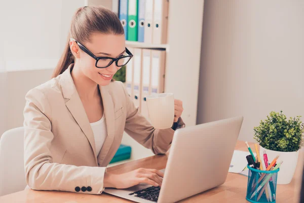 Ritratto di bella giovane donna che lavora con laptop e drinki — Foto Stock