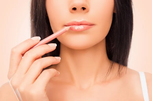 Foto de cerca de una joven haciendo maquilaje con revestimiento de labios —  Fotos de Stock