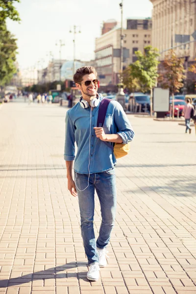 Vrolijke jonge man genieten van wandeling de stad — Stockfoto