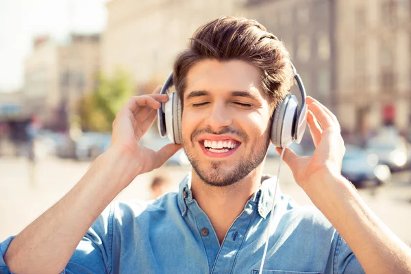 Alegre joven disfrutando de la música con auriculares — Foto de Stock