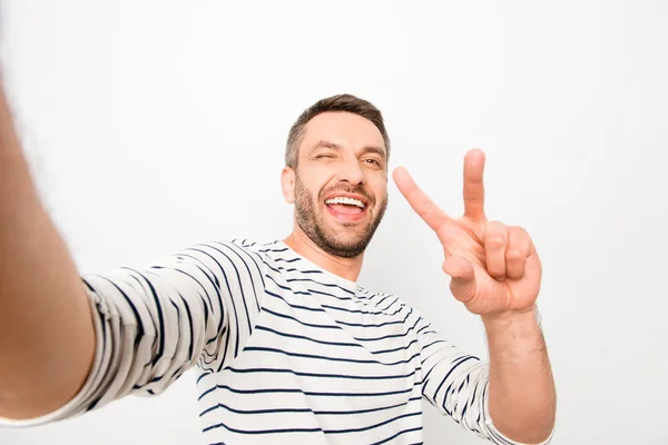 Feliz hombre risueño alegre haciendo selfie y mostrando dos dedos — Foto de Stock