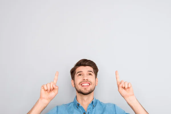 Stilig man gestikulerande med fingrar under huvudet på grå bak — Stockfoto