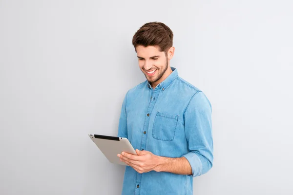 Hombre guapo usando tableta digital sobre fondo gris — Foto de Stock