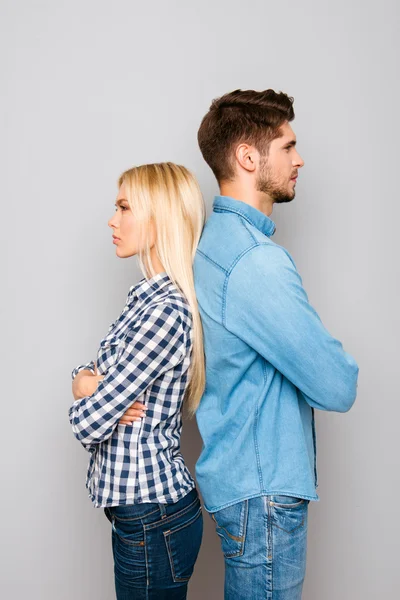 Serious man and woman with crossed hands standing back to back — Stock Photo, Image