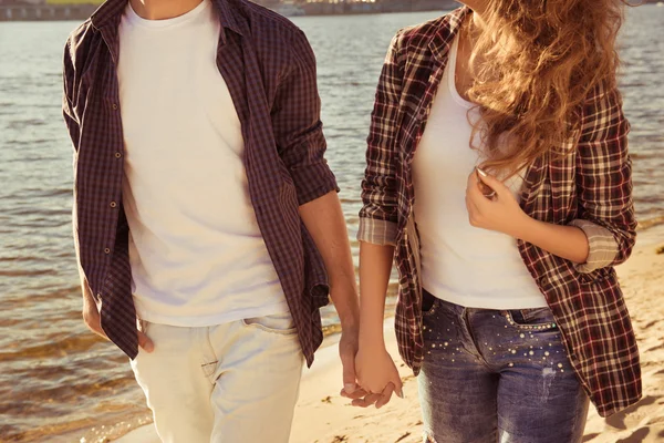 Крупним планом чоловік і жінка тримаються за руки і ходять на пляжі — стокове фото