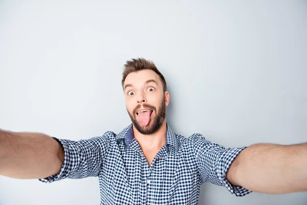 Glücklicher Mann macht komisches Selfie und zeigt Zunge — Stockfoto