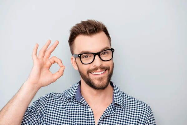 Веселий молодий чоловік в окулярах показує жест "ОК" — стокове фото