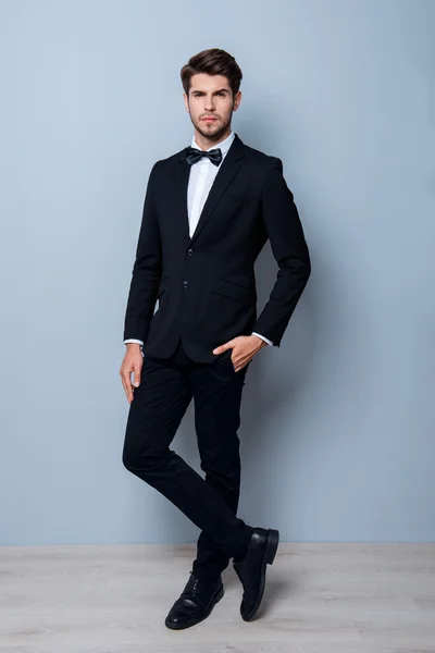 Handsome young successful businessman posing in black suit — Stock Photo, Image