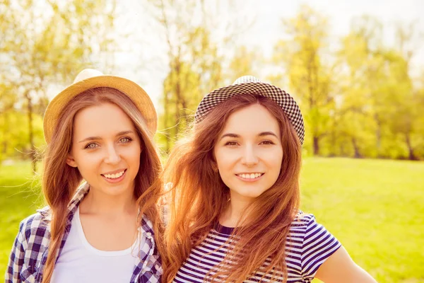 Portrait of young girls in hats with beamings smiles in the park — Stock Photo, Image