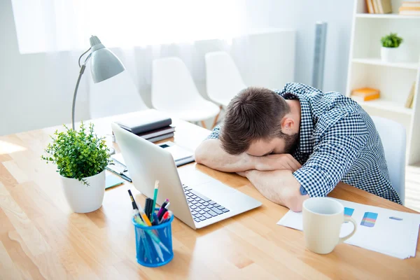 Hombre agotado durmiendo en el lugar de trabajo después de un duro día de trabajo — Foto de Stock