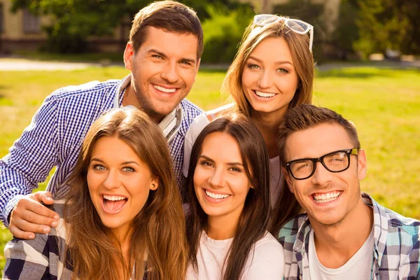 Fröhliche fünf Freunde umarmen und ruhen sich an sonnigem Tag aus — Stockfoto