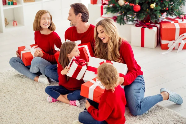 Portret van mooie aantrekkelijke grote vol vrolijke schattige familie zitten op de vloer uitwisselen giftboxen Eve Noel December Nieuwjaar hebben plezier in licht wit appartement huis binnen — Stockfoto