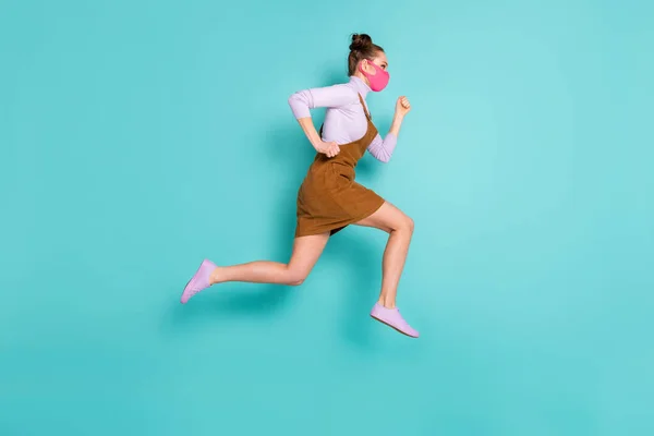 Full body profile photo of attractive lady speed fast hurry catch bus stay safe pink face mask wear trendy fall short brown dress purple sneakers pullover isolated turquoise color background