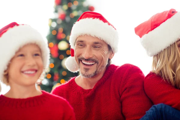Portret van positieve papa vader kijk naar zijn zoon dragen santa claus cap in huis met x-mas kerst ornament — Stockfoto
