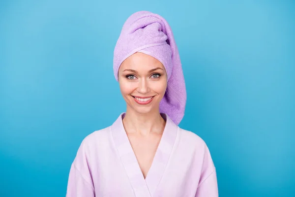 Foto de encantador jovem senhora toothy radiante sorriso desgaste violeta toalha turbante roupão isolado azul cor de fundo — Fotografia de Stock