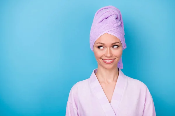 Photo de jolie dame sourire brillant regarder espace vide porter pourpre serviette turban peignoir isolé fond de couleur bleue — Photo