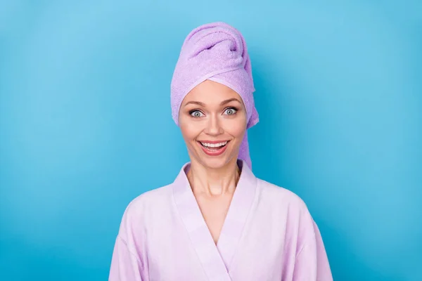 Foto de linda senhora radiante sorriso surpreendido olhar câmera desgaste roxo toalha turbante roupão isolado azul cor fundo — Fotografia de Stock