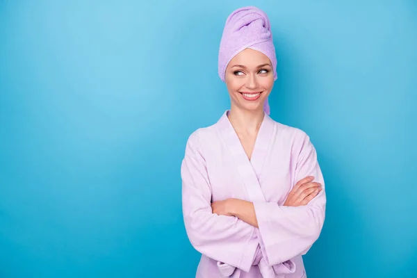 Foto de encantadora senhora dobrado mãos toothy sorriso olhar espaço vazio desgaste toalha violeta turbante banho roupão isolado azul cor fundo — Fotografia de Stock