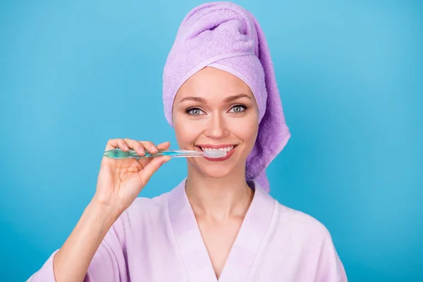 Фото красивой молодой леди чистки зубов подготовки износа фиолетовый полотенце банный халат изолированный синий цвет фона — стоковое фото
