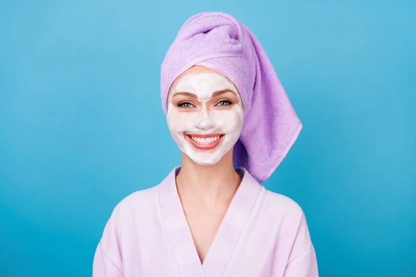 Фото красивой девушки пены для лица маска блестящая белая улыбка носить фиолетовый полотенце банный халат изолированный синий цвет фона — стоковое фото