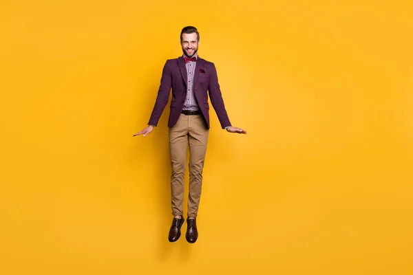 Full body foto van knappe stijlvolle goed geklede zakenman springen hoog op goed humeur flirterige look dragen geruite shirt blazer broek schoenen geïsoleerde gele kleur achtergrond — Stockfoto