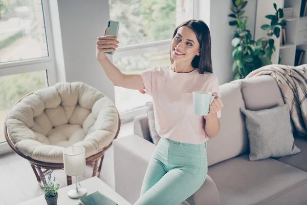 Foto portrét ženy sociální média vliv ukazující její ranní rutinní držení pohár dělat selfie uvnitř — Stock fotografie