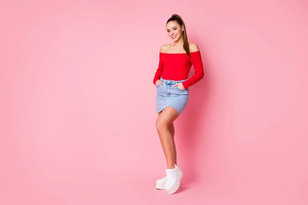 Foto de longitud completa de la señora atractiva agradable forma delgada figura brazos bolsillos sonrisa dentada desgaste casual rojo abierto hombros camisa mini falda de mezclilla calzado aislado pastel rosa color fondo — Foto de Stock