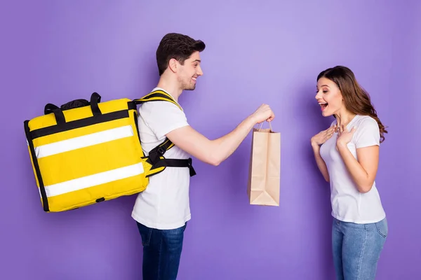 Profile photo amazed overjoyed lady courier guy hold present bag delivery speed best service quarantine birthday house order wear t-shirts jeans isolated purple color background — Stock Photo, Image