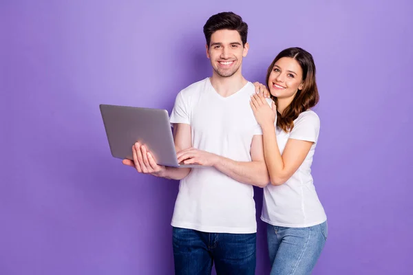 Portré pozitív pár férfi nő hold laptop munka otthonról van online partnerség kommunikáció viselni fehér póló alkalmi stílus farmer elszigetelt felett lila színű háttér — Stock Fotó