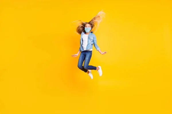 Foto de tamaño completo del cuerpo de la niña de pelo largo y rubio saltar de alta desgaste jeans máscara camisa aislada sobre fondo de color amarillo brillante —  Fotos de Stock