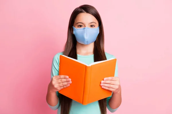 Foto van mooie charmante langharige meisje lezen boek dragen respiratoire teal shirt geïsoleerde roze pastel kleur achtergrond — Stockfoto