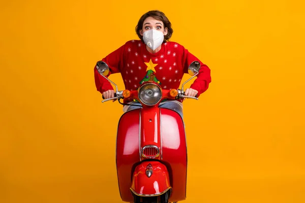 Foto de chica sorprendida conducir scooter rápido usar máscara árbol de navidad decoración jersey jersey aislado brillo color fondo — Foto de Stock