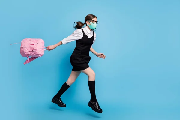 Volle Länge Profil Seite Foto von High School Mädchen springen laufen schnell Vorlesung halten Rucksack Rucksack tragen weiße Bluse schwarzes Rockkleid lange Socken insgesamt isoliert blaue Farbe Hintergrund — Stockfoto