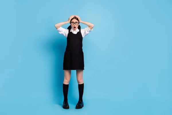 Foto de comprimento total de surpreendido menina toque mãos cabeça ver inesperado pós-graduação programa de exames informações impressionado desgaste uniforme geral isolado sobre fundo de cor azul — Fotografia de Stock