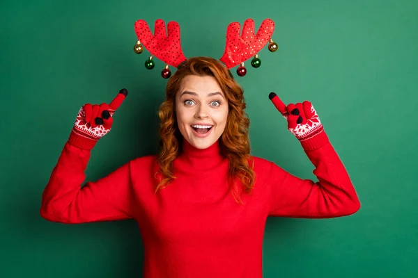 Fotografie funky mladé dívky ukazují prsty sobí parohy nosit červené rukavice svetr jelení rohy izolované zelené barvy pozadí — Stock fotografie