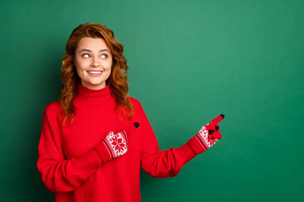 Fénykép a csinos lány jelzi ujjak megjelenés oldalán üres tér kopás piros pulóver kesztyű elszigetelt zöld szín háttér — Stock Fotó