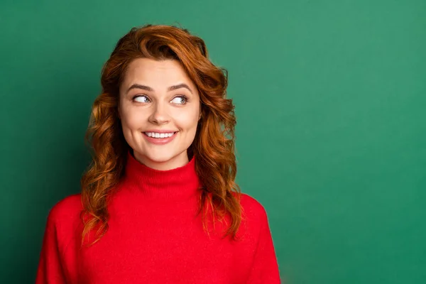 Фото прекрасной юной леди смотреть сторону пустое пространство блестящая улыбка носить красный свитер изолированный зеленый цвет фона — стоковое фото