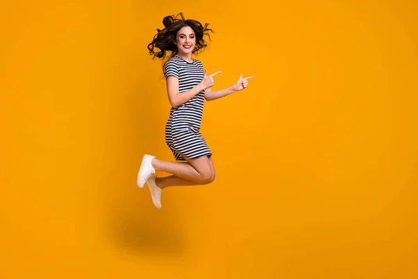 フルボディプロフィール写真のファンキーな巻き女性ジャンプ高直接指空スペースアドバイス黒金曜日販売着用白カジュアルストライプショートドレスシューズ隔離された黄色の色背景 — ストック写真