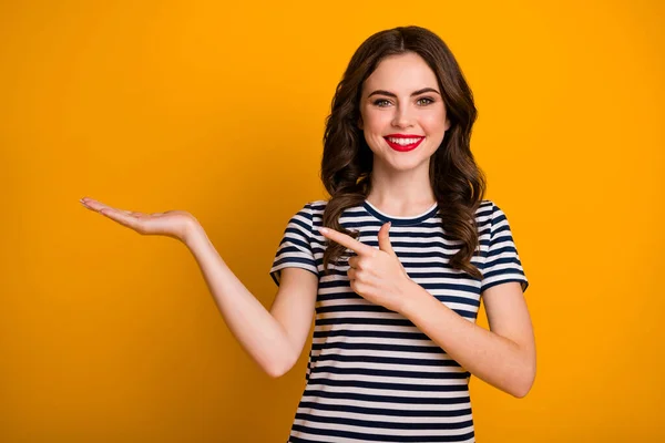 Retrato dela ela agradável-olhando atraente linda alegre alegre menina de cabelos ondulados segurando em anúncio de palma conselho de decisão isolado no brilho vívido brilhante vibrante cor amarela fundo — Fotografia de Stock