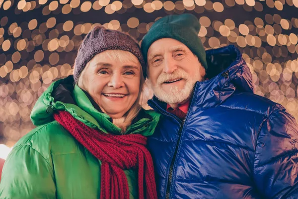 美しい古い結婚したカップルの女性の写真男は夜のライトで屋外でX-masクリスマスジョリーホリーお祝いを楽しむアウターウェア帽子スカーフ — ストック写真