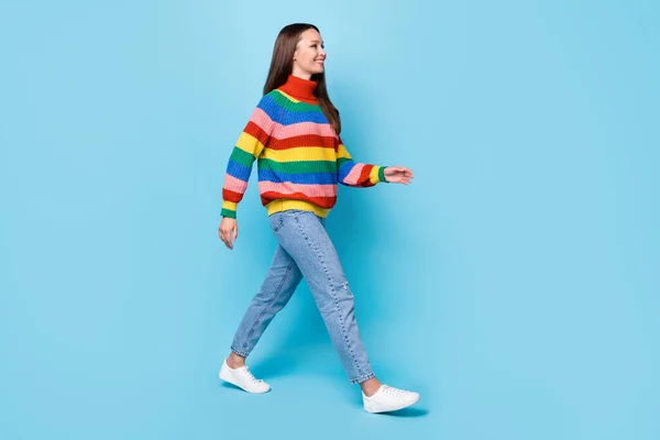 Full length body size side view of her she nice attractive cheerful cheery brown-haired girl walking wearing cosy garment isolated bright vivid shine vibrant blue color background — стоковое фото