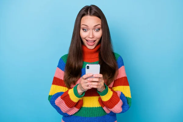 Portret zadziwionej szalonej dziewczyny używać smartfona blogowanie pod wrażeniem sieci społecznościowej aktualności komentarz krzyczeć wow omg nosić sweter odizolowany na tle niebieskiego koloru — Zdjęcie stockowe