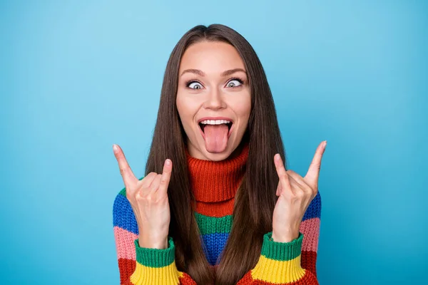 Portrait of childish playful crazy youth girl student fooling make horned symbol show tongue out wear style stylish trendy sweater isolated over blue color background