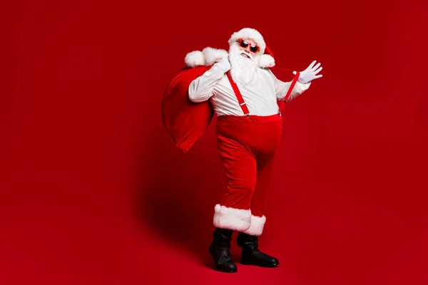 In voller Länge Körpergröße Ansicht seiner er attraktiv verspielt fröhlich lustig Fett Santa tragen großen großen Sack Spaß beim Narren genießen isoliert hell lebendigen Glanz lebendige rote Farbe Hintergrund — Stockfoto
