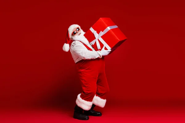 Vista completa del tamaño del cuerpo de su atractivo padre de Santa alegre llevando gran caja de regalo grande entrega rápida venta descuento aislado brillante brillo vivo vibrante color rojo fondo —  Fotos de Stock