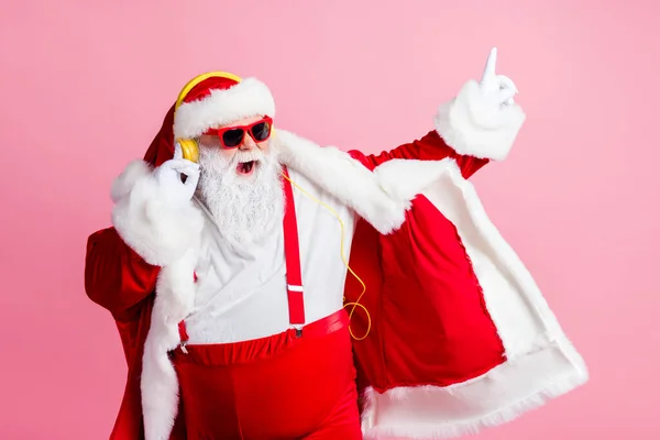 Foto di pazzo funky Babbo Natale godere di ascoltare x-mas Natale nuovo anno fata radio canzone cuffie indossare pantaloni di occhiali da sole bretelle isolato su sfondo di colore pastello — Foto Stock