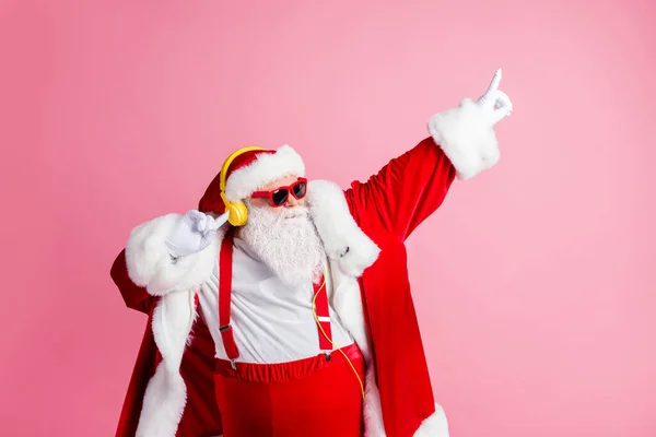 Photo funky cool Santa Claus mają x-mas Boże Narodzenie impreza uroczystości słuchać słuchawki muzyka podnieść palce taniec nosić sunglass szelki czapka nakrycie głowy odizolowany pastelowy kolor tła — Zdjęcie stockowe