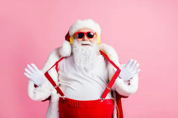 Photo funny funky overweight santa claus enjoy listen x-mas christmas radio fairy songs headphones pull hands suspenders wear sunglass pants headwear cap isolated pastel color background — Stock Photo, Image