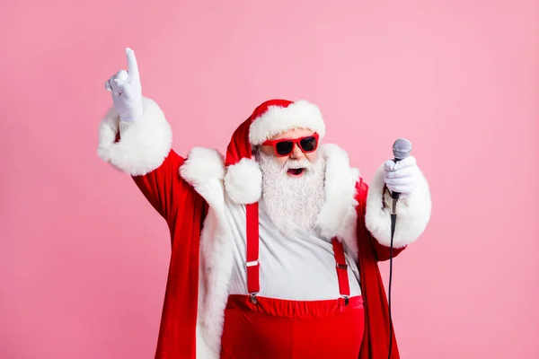 North-pole celebrity white grey hair beard santa claus big belly sing x-mas christmas songs hold microphone raise fingers wear suspenders sunglass headwear isolated pastel color background